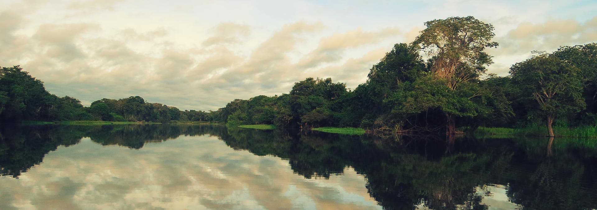 Expedition boat navigating the tranquil waters of the Amazon River basin near Iquitos
